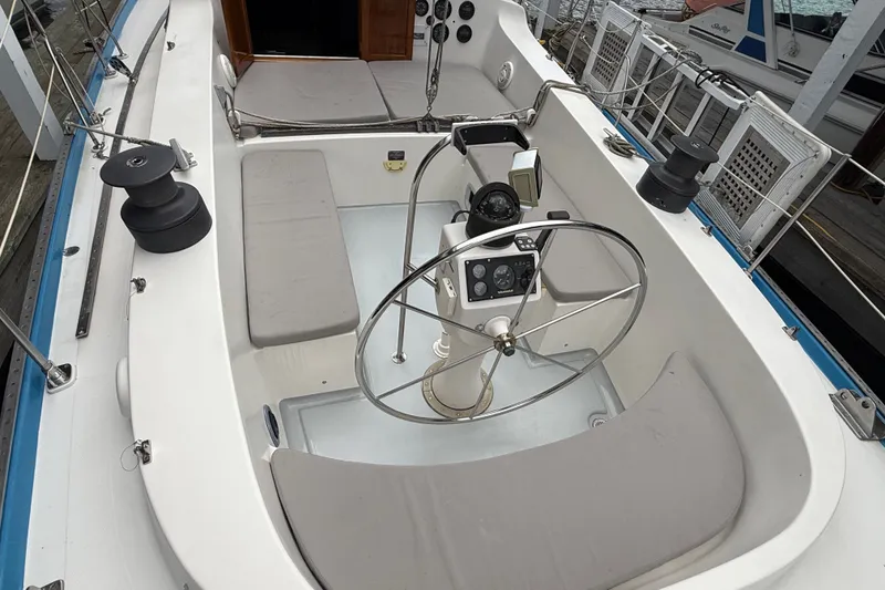 Slide: The Image of 1974 Spencer 53 sailboat cockpit with steering wheel and cushioned seating. - 5