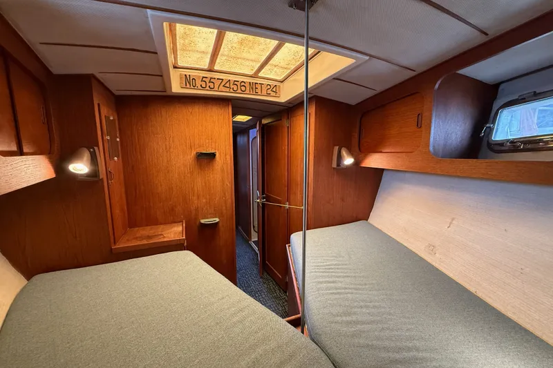 Slide: The Image of Cozy cabin interior of a 1974 Spencer 53 sailboat with wooden paneling and twin beds. - 20