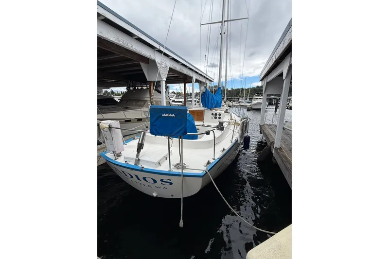 Slide: The Image of 1974 Spencer 53 sailboat docked in a marina under a cloudy sky. - 65