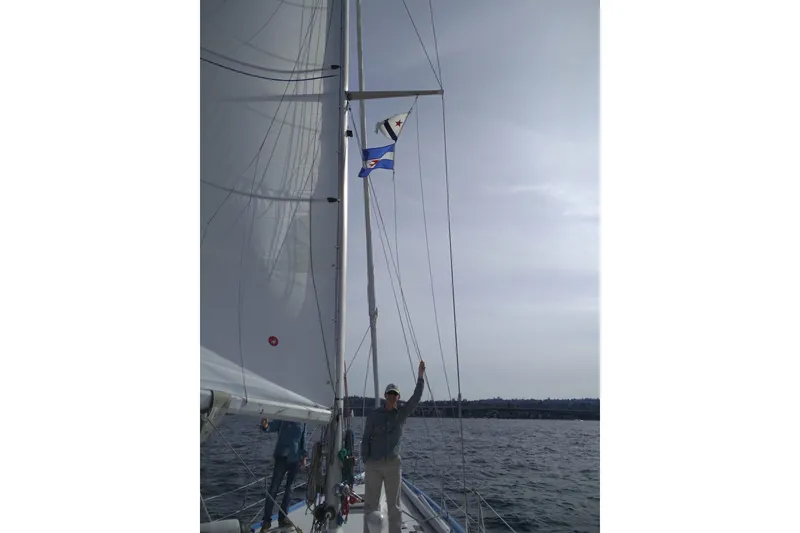 Slide: The Image of Sailing on a 1974 Spencer 53 yacht with flags, calm sea, and clear sky. - 69