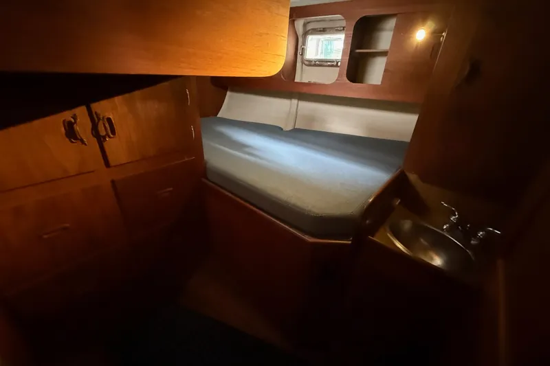 Slide: The Image of Cozy cabin interior of 1974 Spencer 53 yacht with bed, sink, and wooden storage. - 29