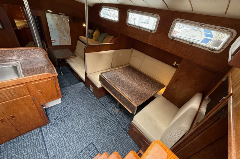 Slide: The Image of Interior of a 1974 Spencer 53 sailboat with cozy seating and wooden cabinetry. - 8