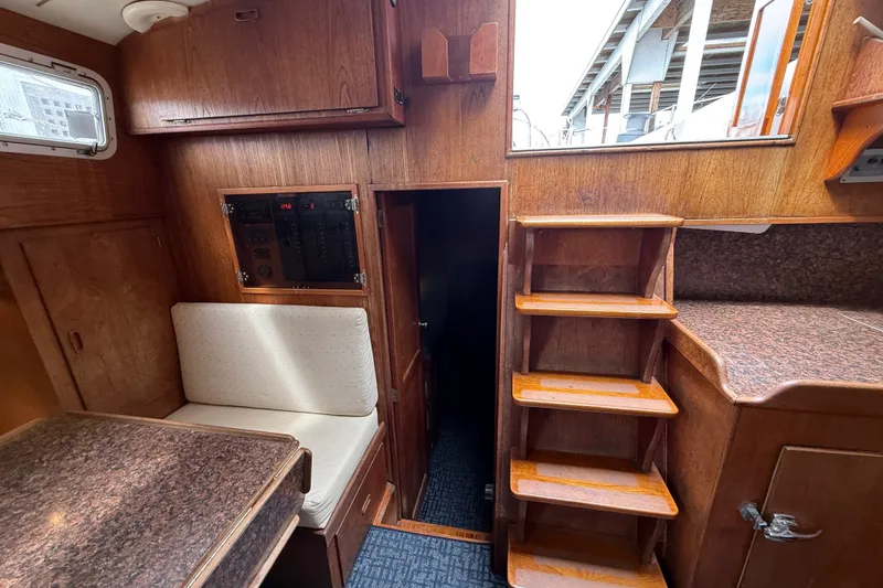 Slide: The Image of 1974 Spencer 53 yacht interior with wooden cabinetry, seating, and stairs. - 12