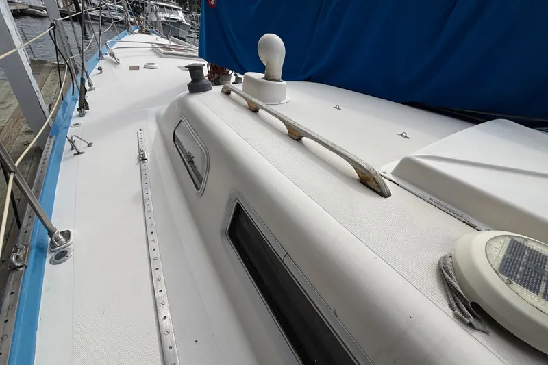 Slide: The Image of 1974 Spencer 53 sailboat deck with blue cover and docked at marina. - 1
