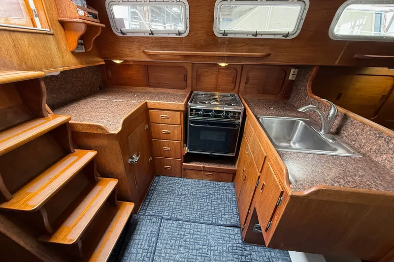 Slide: The Image of 1974 Spencer 53 yacht kitchen with wood cabinetry, stove, and sink. - 11