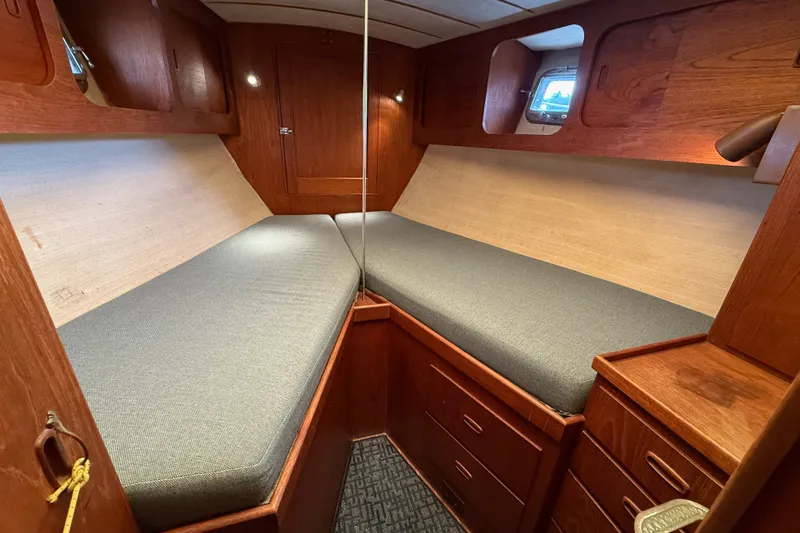 Slide: The Image of Cozy cabin interior of a 1974 Spencer 53 sailboat with wooden furnishings and twin beds. - 19