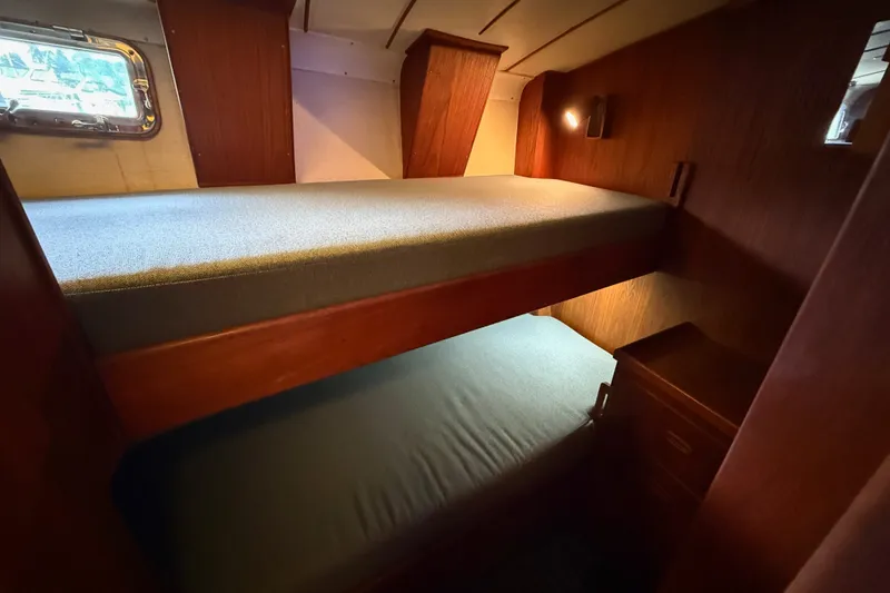 Slide: The Image of Interior of a 1974 Spencer 53 yacht featuring cozy wooden bunk beds. - 21