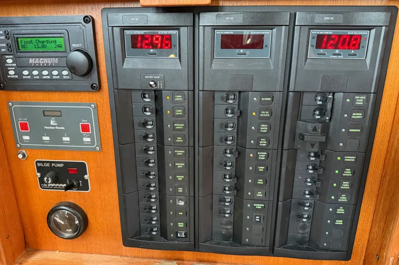 Slide: The Image of Electrical control panel on a 1974 Spencer 53 boat, featuring voltage displays and switches. - 52