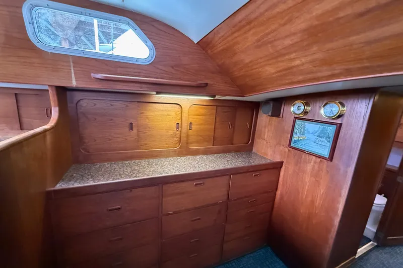 Slide: The Image of 1974 Spencer 53 yacht interior with wooden cabinetry and nautical instruments. - 15