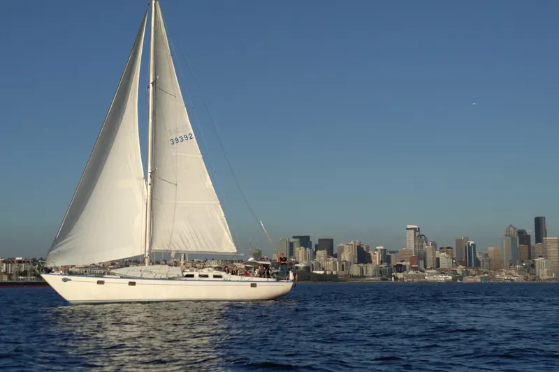 The Image of Sailboat Spencer 53 (1974) cruising near city skyline under clear blue sky. - 0