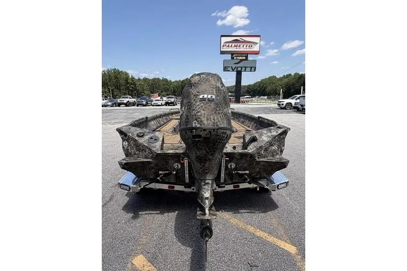 Slide: The Image of 2027 Excel 183 Tomahawk boat with camouflage design, parked outdoors near dealership. - 8