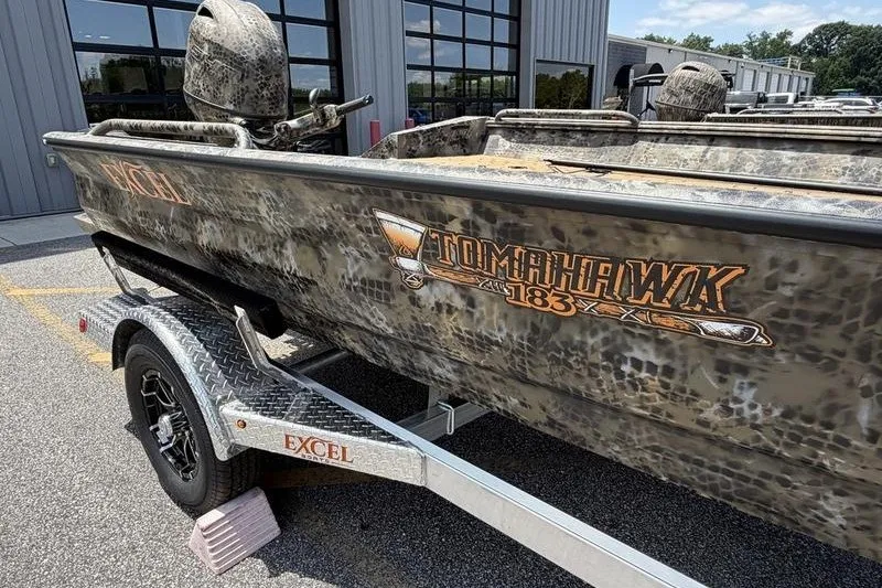 Slide: The Image of 2027 Excel 183 Tomahawk boat with camouflage design on a trailer. - 6