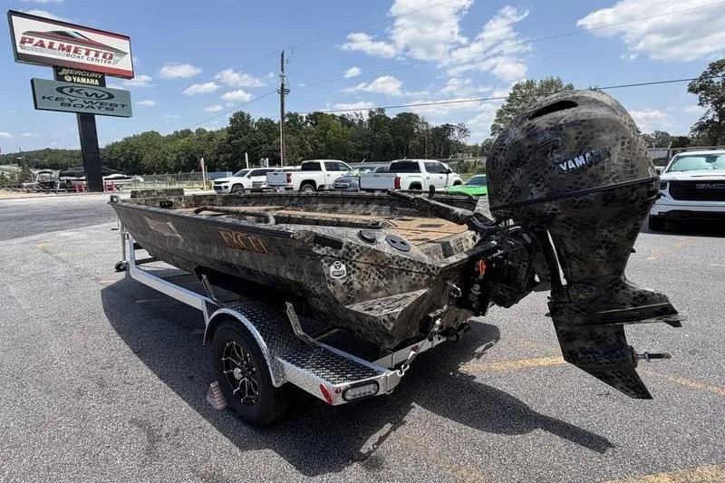 Slide: The Image of Camouflage-patterned 2027 Excel 183 Tomahawk boat on trailer at dealership parking lot. - 13