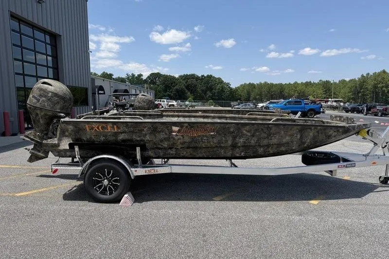 Slide: The Image of 2027 Excel 183 Tomahawk boat on trailer, parked outdoors under clear sky. - 9