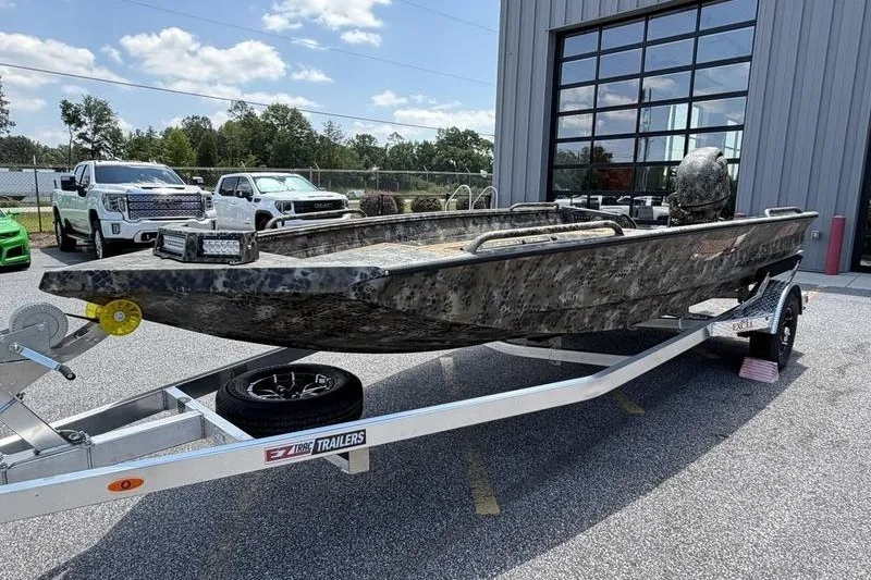 Slide: The Image of 2027 Excel 183 Tomahawk boat on trailer outside a modern building. - 11
