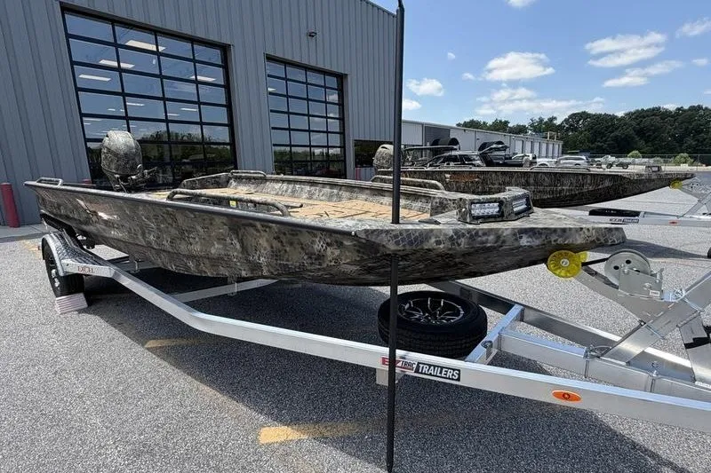 Slide: The Image of 2027 Excel 183 Tomahawk boat on trailer outside a modern building. - 3