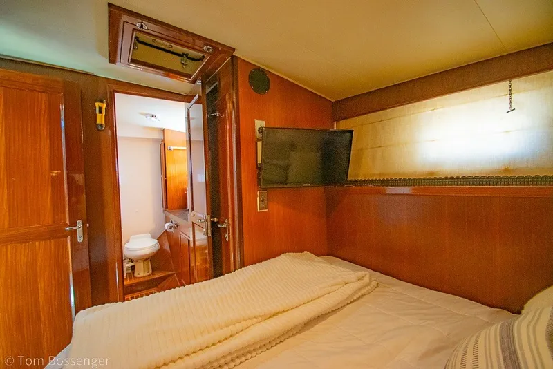 Slide: The Image of Cozy cabin interior of 1987 Hatteras 52 Convertible yacht with bed, TV, and bathroom. - 25