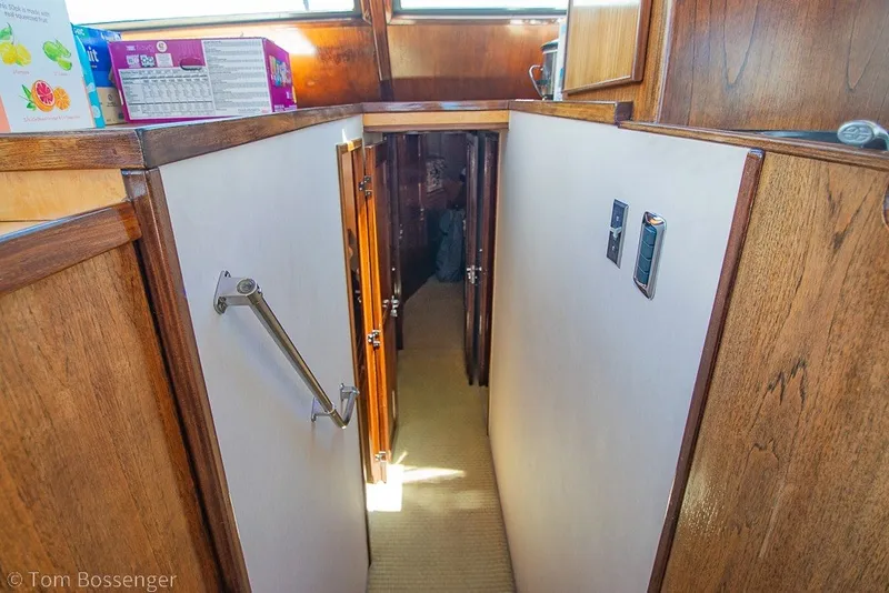 Slide: The Image of Interior hallway of a 1987 Hatteras 52 Convertible yacht with wooden accents. - 22