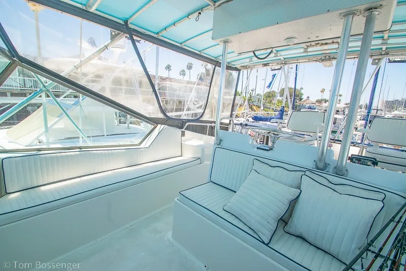Slide: The Image of Interior of 1987 Hatteras 52 Convertible yacht with cushioned seating and marina view. - 49