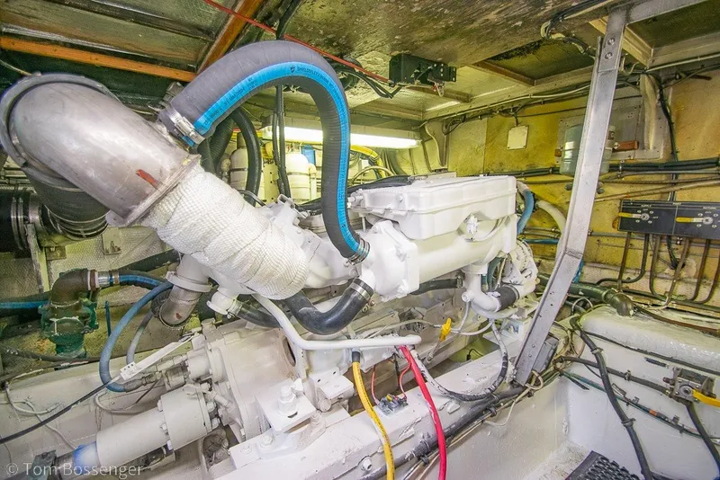Slide: The Image of Engine room of 1987 Hatteras 52 Convertible yacht, showcasing mechanical components and wiring. - 61