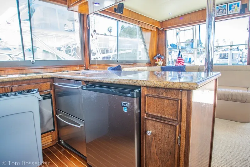 Slide: The Image of Interior of 1987 Hatteras 52 Convertible yacht with wooden cabinetry and modern appliances. - 14