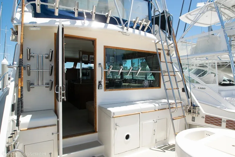 Slide: The Image of 1987 Hatteras 52 Convertible yacht with open cabin door and fishing rod holders. - 41