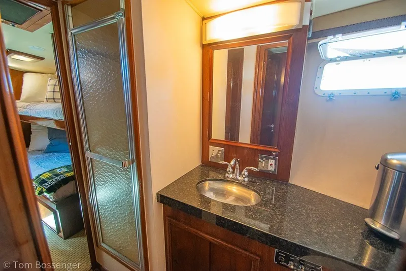 Slide: The Image of 1987 Hatteras 52 Convertible yacht bathroom with sink, mirror, and shower. - 34