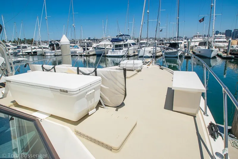 Slide: The Image of 1987 Hatteras 52 Convertible yacht docked in a marina, surrounded by other boats. - 53