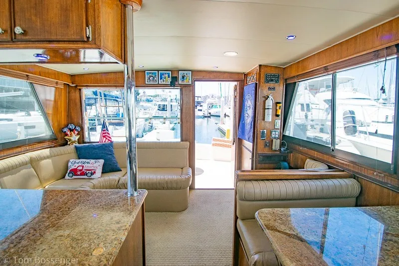 Slide: The Image of Interior of 1987 Hatteras 52 Convertible yacht with luxurious seating and marina view. - 21