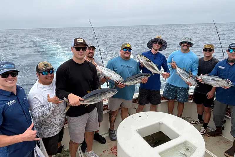 Slide: The Image of Group of fishermen holding tuna on a 1987 Hatteras 52 Convertible boat. - 40
