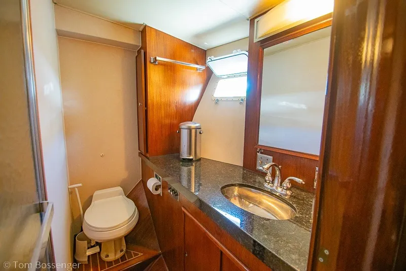 Slide: The Image of Luxurious bathroom interior of 1987 Hatteras 52 Convertible yacht with wood accents and modern fixtures. - 26