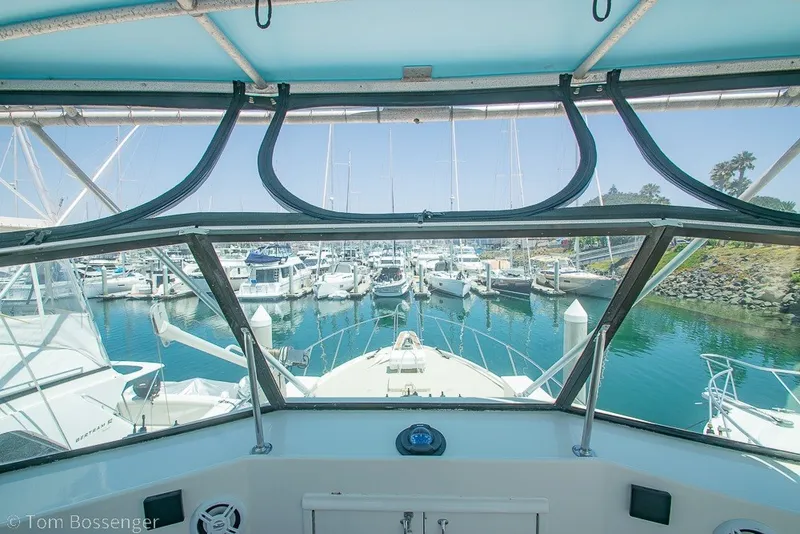 Slide: The Image of View from 1987 Hatteras 52 Convertible yacht cockpit overlooking marina with boats and clear sky. - 51