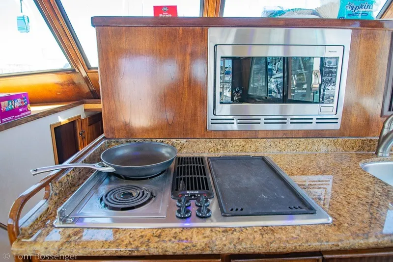 Slide: The Image of 1987 Hatteras 52 Convertible yacht kitchen with stove, frying pan, and microwave. - 16