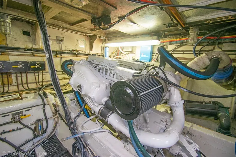 Slide: The Image of Engine room of a 1987 Hatteras 52 Convertible yacht, showcasing mechanical components and wiring. - 62