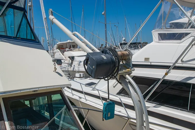 Slide: The Image of 1987 Hatteras 52 Convertible yacht docked in marina, featuring winch and clear blue sky. - 58