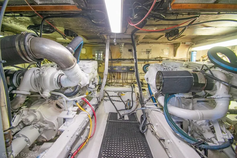 Slide: The Image of Engine room of a 1987 Hatteras 52 Convertible yacht, showcasing dual engines and wiring. - 60