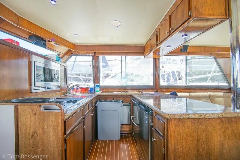 Slide: The Image of Interior of 1987 Hatteras 52 Convertible yacht with wooden cabinetry and modern appliances. - 13