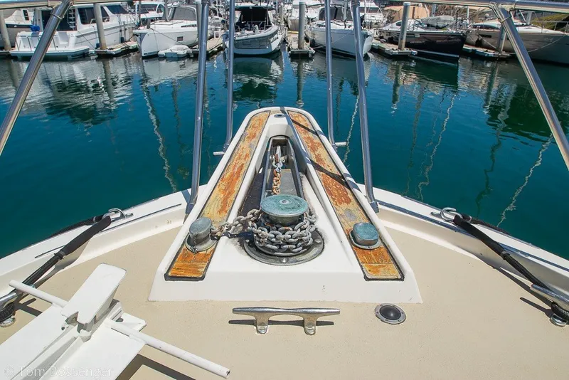 Slide: The Image of Bow of 1987 Hatteras 52 Convertible yacht with anchor chain in marina. - 56