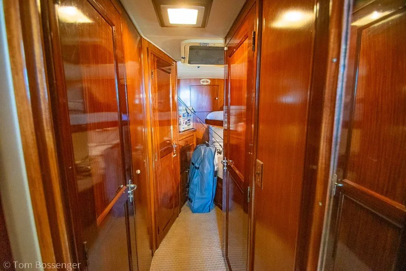 Slide: The Image of Interior hallway of 1987 Hatteras 52 Convertible yacht with wooden paneling and carpeted floor. - 30