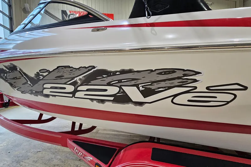 Slide: The Image of 2010 Tigé 22Ve boat with bold graphics on a red trailer. - 20