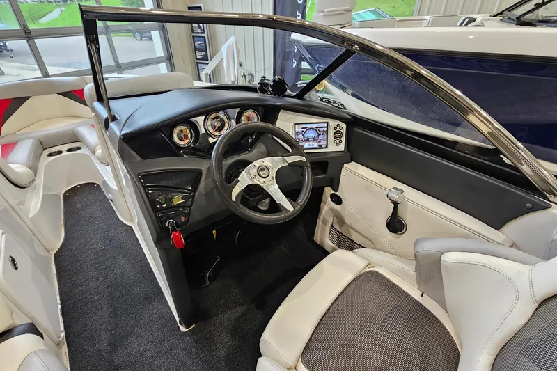 Slide: The Image of Interior view of 2010 Tigé 22Ve boat cockpit with steering wheel and dashboard controls. - 12