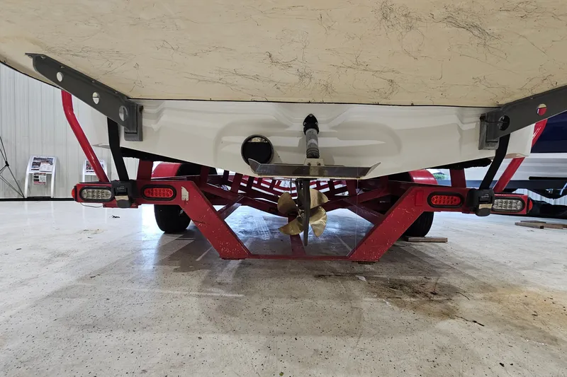 Slide: The Image of 2010 Tigé 22Ve boat on red trailer, showcasing propeller and undercarriage details. - 6
