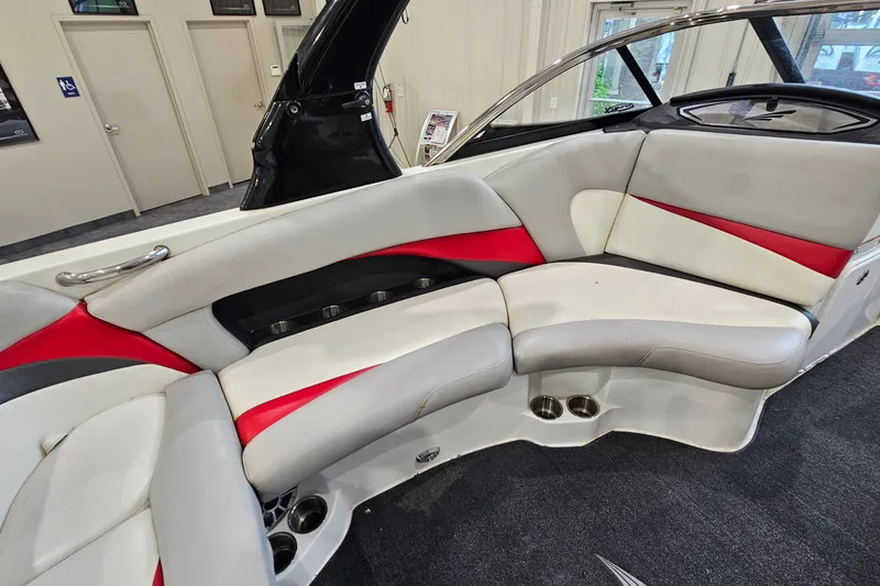 Slide: The Image of 2010 Tigé 22Ve boat interior with red and white seating, cup holders, and sleek design. - 11