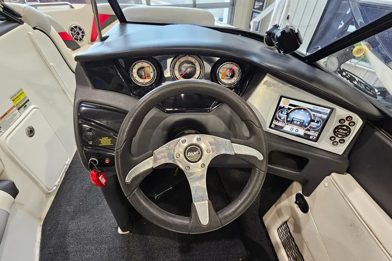Slide: The Image of 2010 Tigé 22Ve boat dashboard with steering wheel, gauges, and touchscreen display. - 13