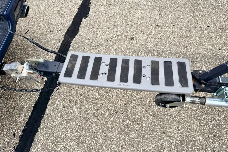Slide: The Image of Trailer hitch with step platform attached to a vehicle, on a paved surface. - 37