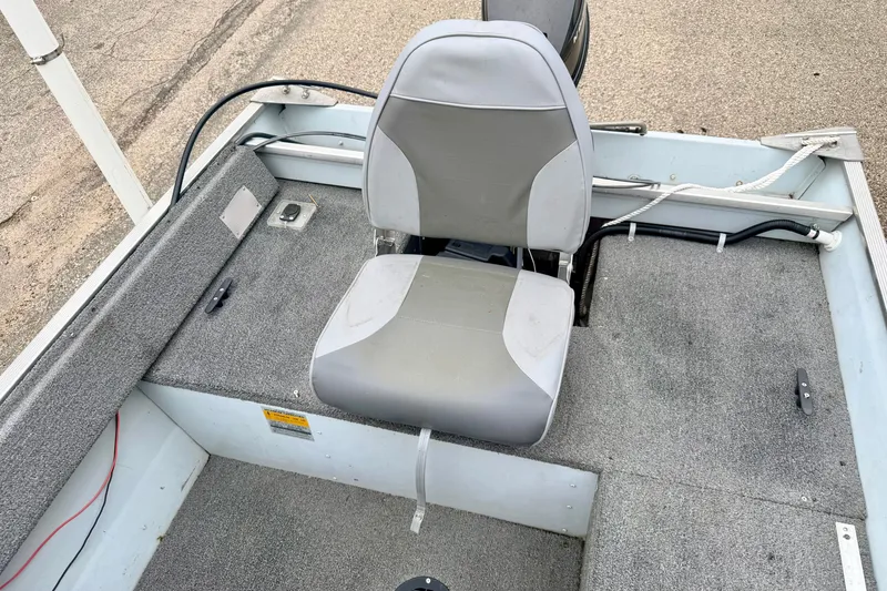 Slide: The Image of 1994 Tracker Guide V-14 boat interior with gray seating and carpeted flooring. - 18