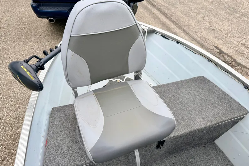 Slide: The Image of 1994 Tracker Guide V-14 boat seat with Minn Kota trolling motor on a gray carpeted deck. - 29