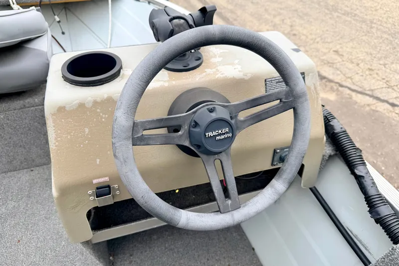Slide: The Image of 1994 Tracker Guide V-14 boat steering wheel and console, featuring a cup holder. - 24