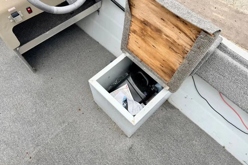 Slide: The Image of Interior of a 1994 Tracker Guide V-14 boat showing storage compartment and steering area. - 22