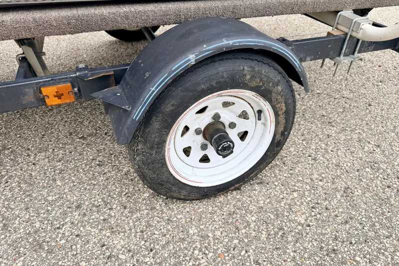 Slide: The Image of Trailer wheel of a 1994 Tracker Guide V-14 Riveted Deep V boat on asphalt. - 40